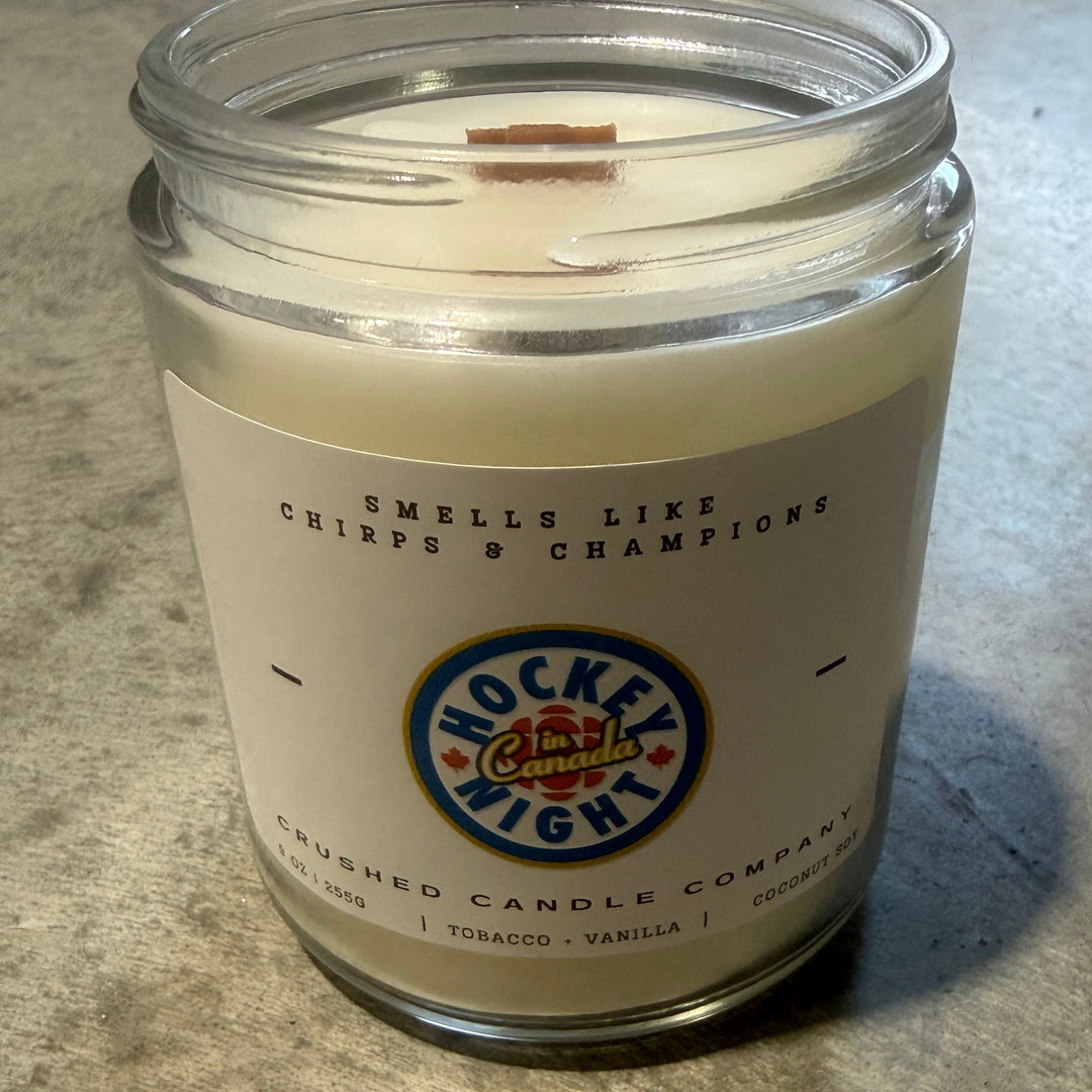 Candle in a glass jar with a label on a concrete surface