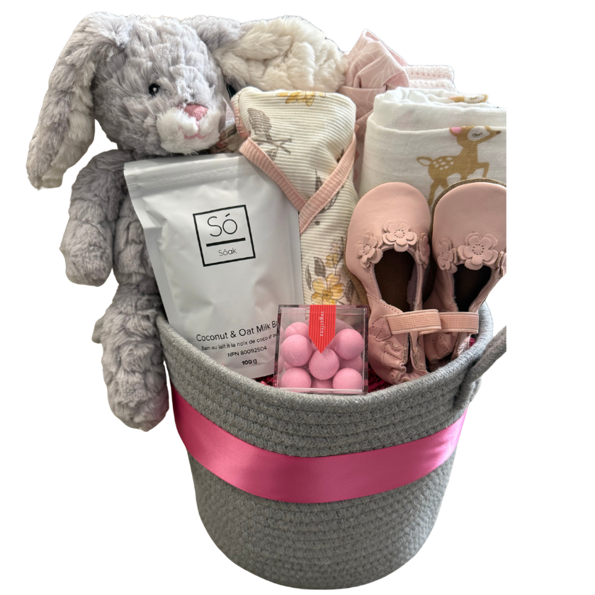 Baby gift basket with plush toys, diapers, and a candle on a white background