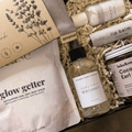 Assorted beauty products including a bottle, tube, and pouches in a box with visible branding.