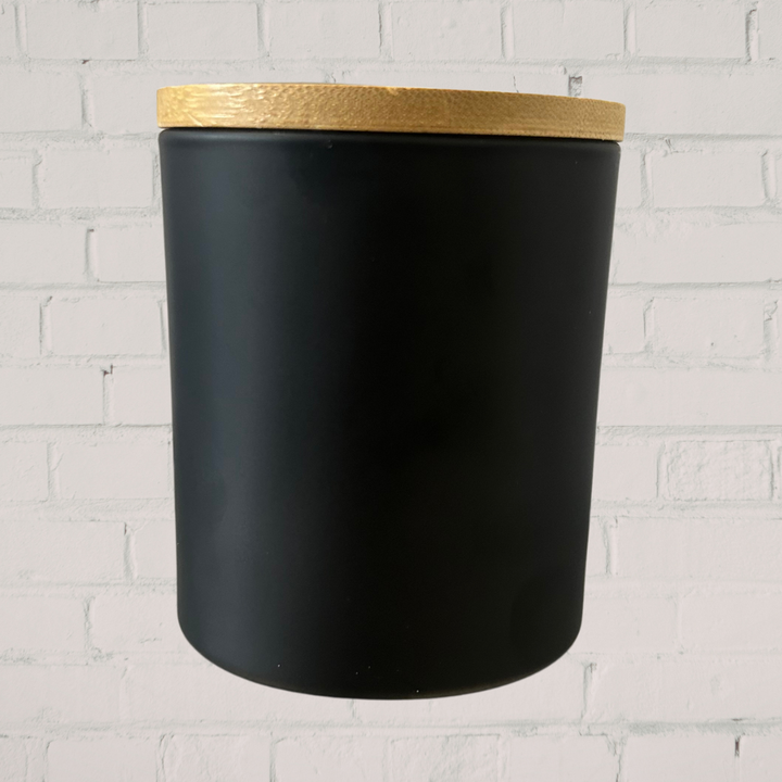 Black  jar with a gold lid on a white brick wall background