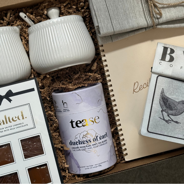 Salted Caramels, Cream & Sugar Containers with a hand towel, tea, recipe book and birdy ground coffee. 