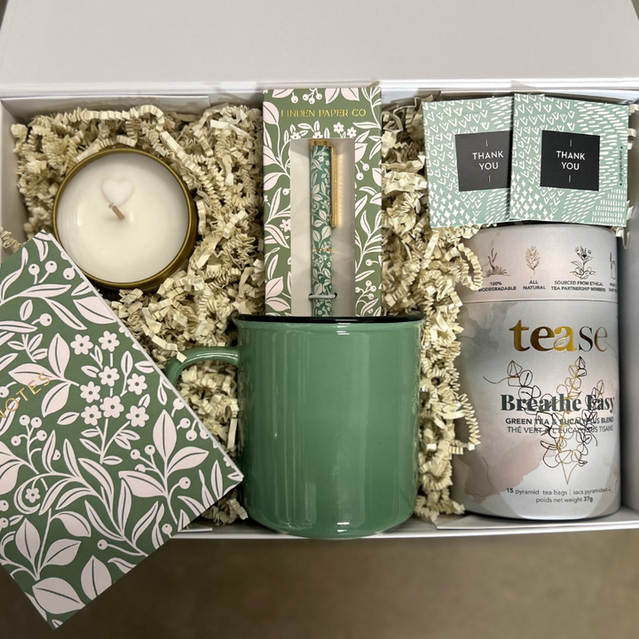 Gift box with tea, mug, candle, notebook and pen