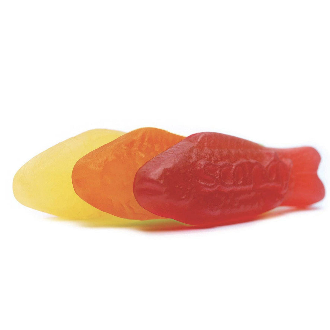 Three gummy fish-shaped candies in red, orange, and yellow on a white background