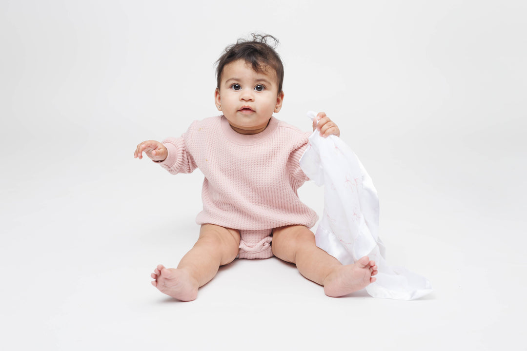 Two Lulujo Baby cotton security blankets with adorable bow designs, soft and cozy for babies.