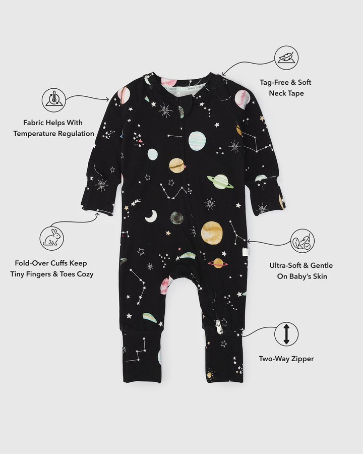 Black baby onesie with space-themed print on a white background, featuring text labels about product features.