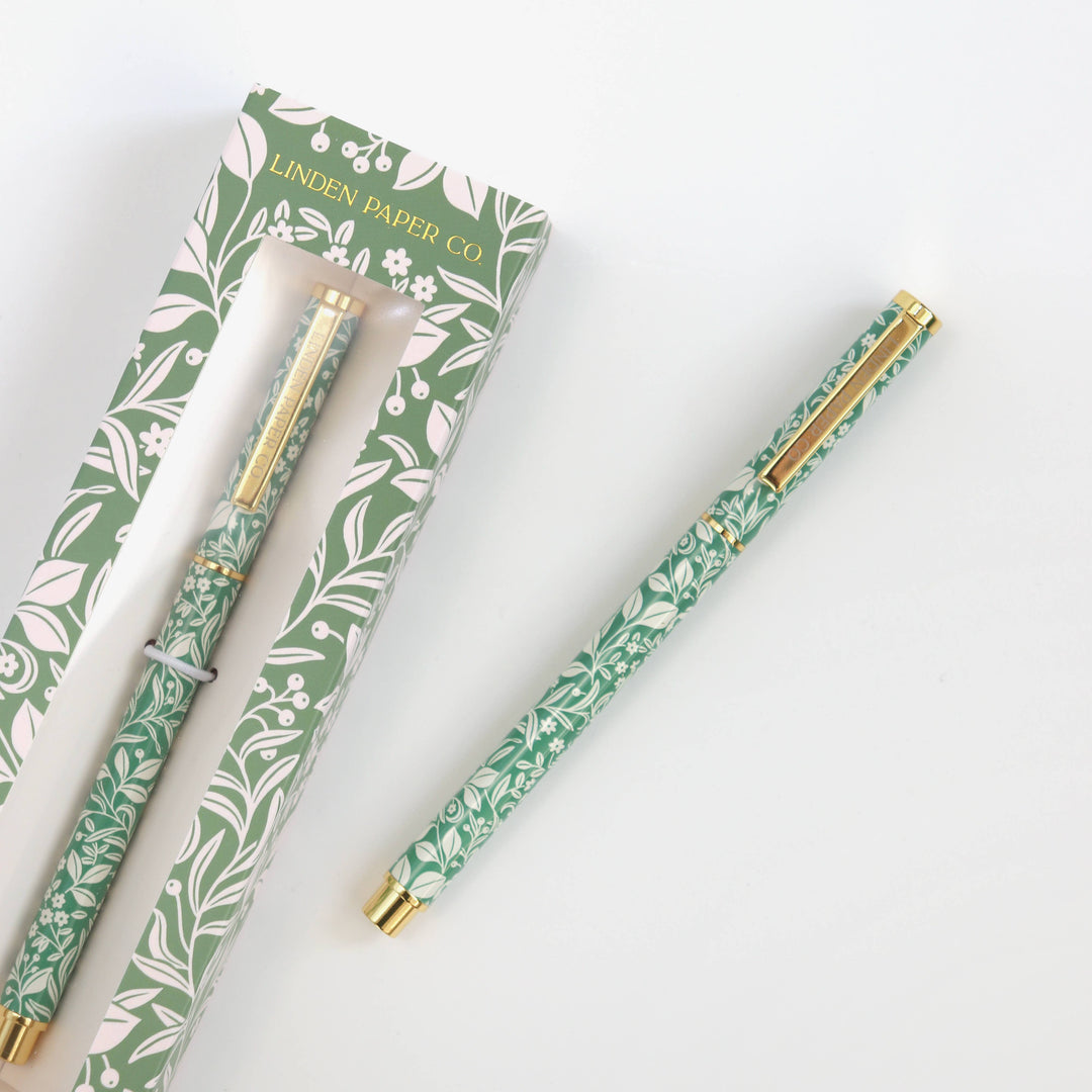 Two patterned pens with gold accents and packaging from Linden Paper Co on a white background