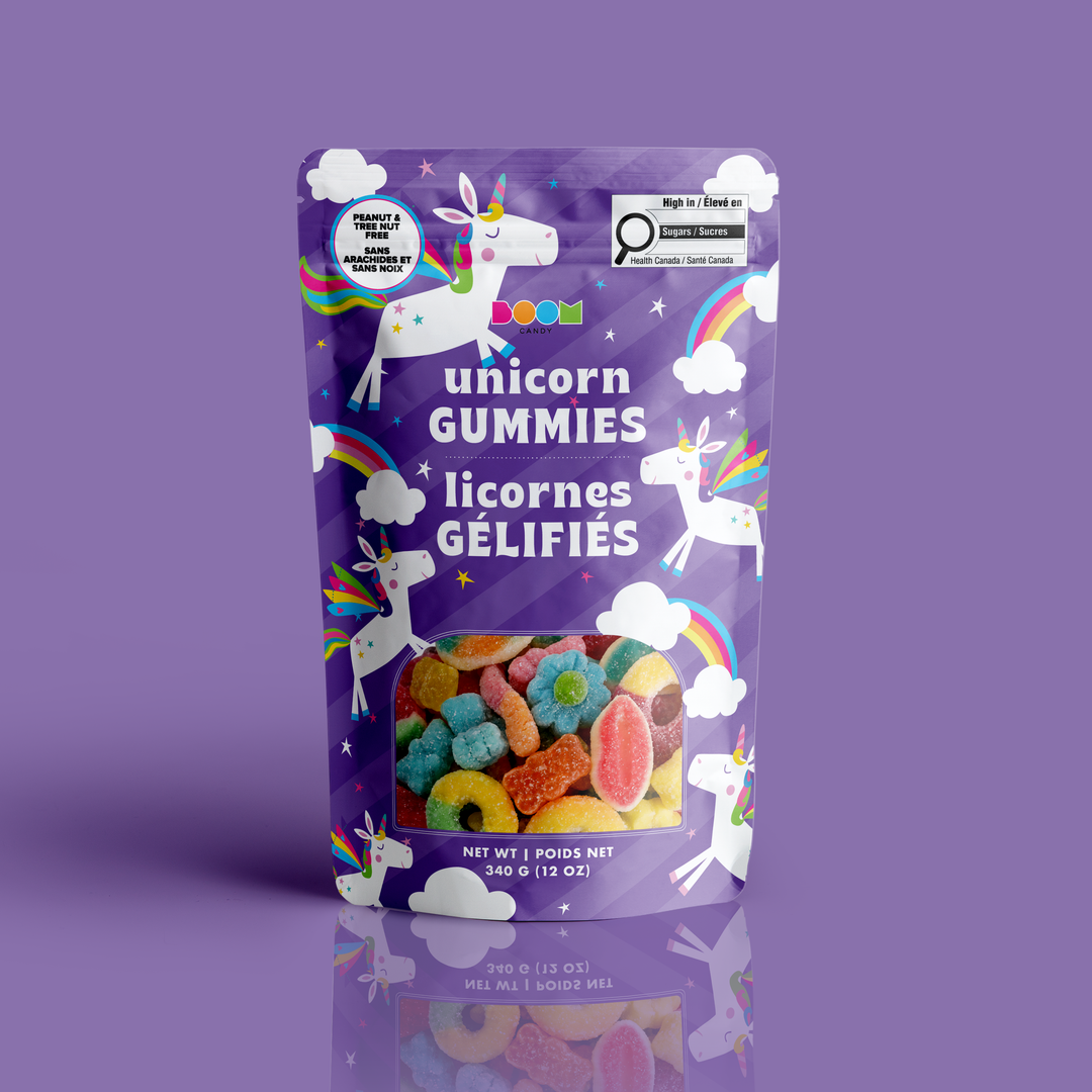 A stand-up pouch of colorful unicorn gummies on a solid purple background. The packaging is primarily purple with illustrations of white unicorns, rainbows, and clouds, and a clear window at the bottom showing the assorted multicolored gummy candies inside.