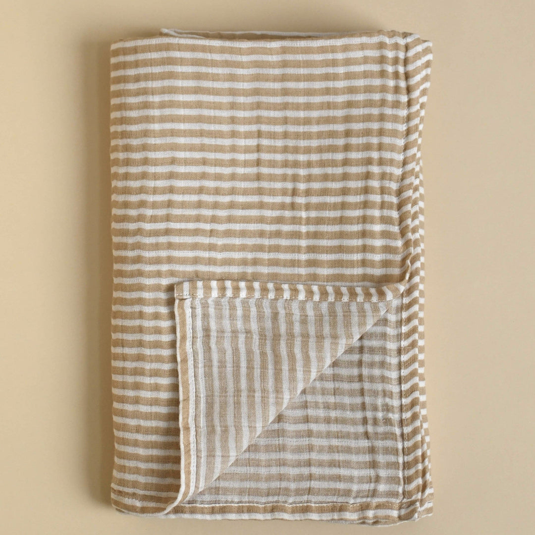 Folded fabric with brown and white stripes on a beige background