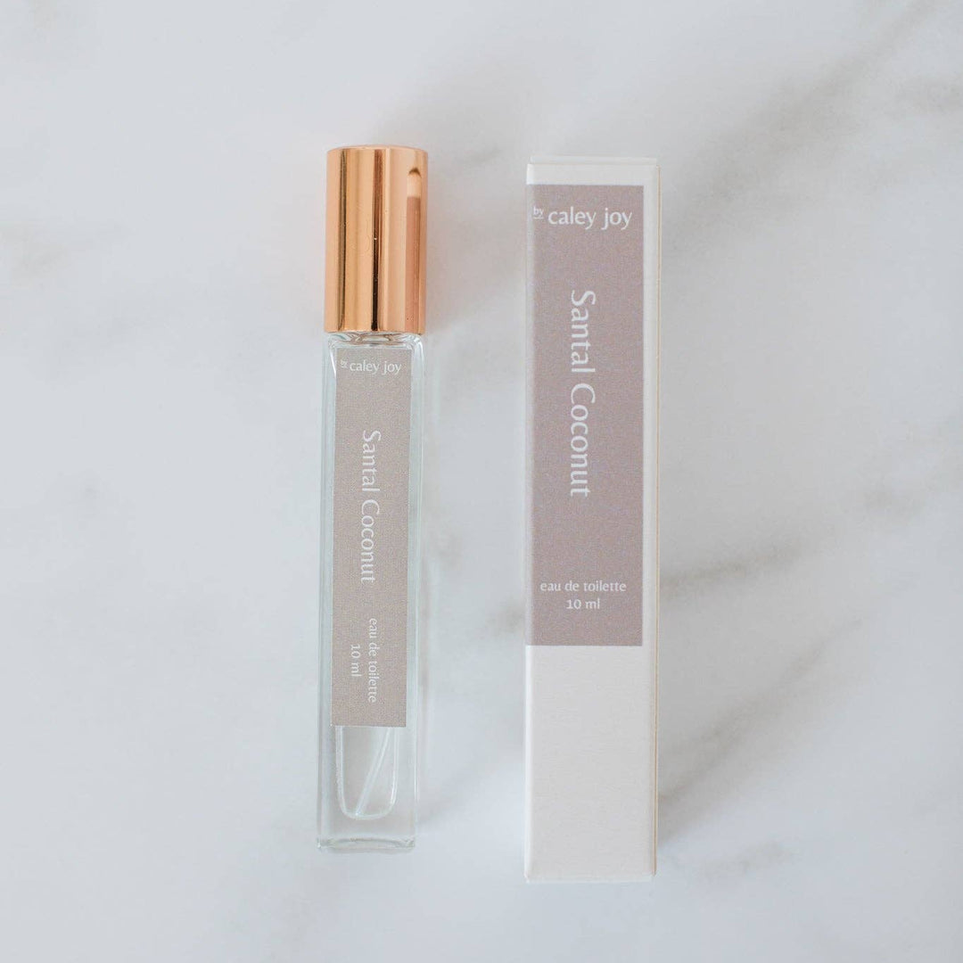 Perfume bottle with gold cap and packaging on a light gray background