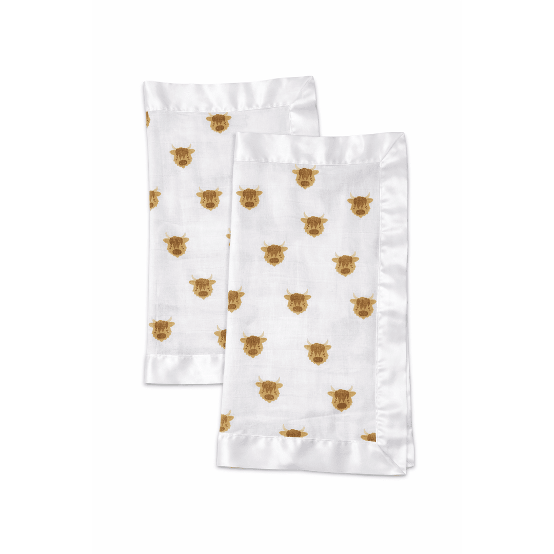 Two white napkins with gold bear patterns on a white background