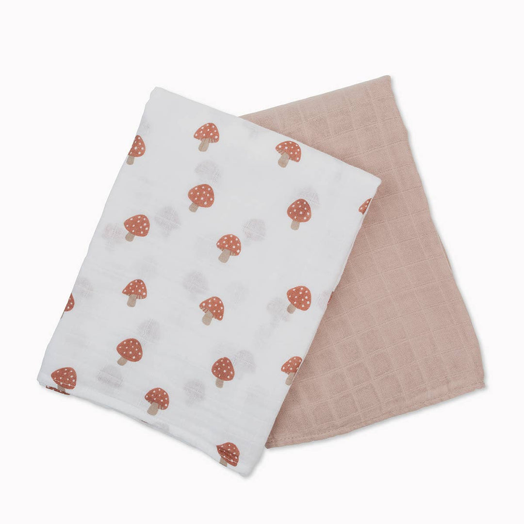 Two baby blankets, one with mushroom pattern and the other plain, on a white background.