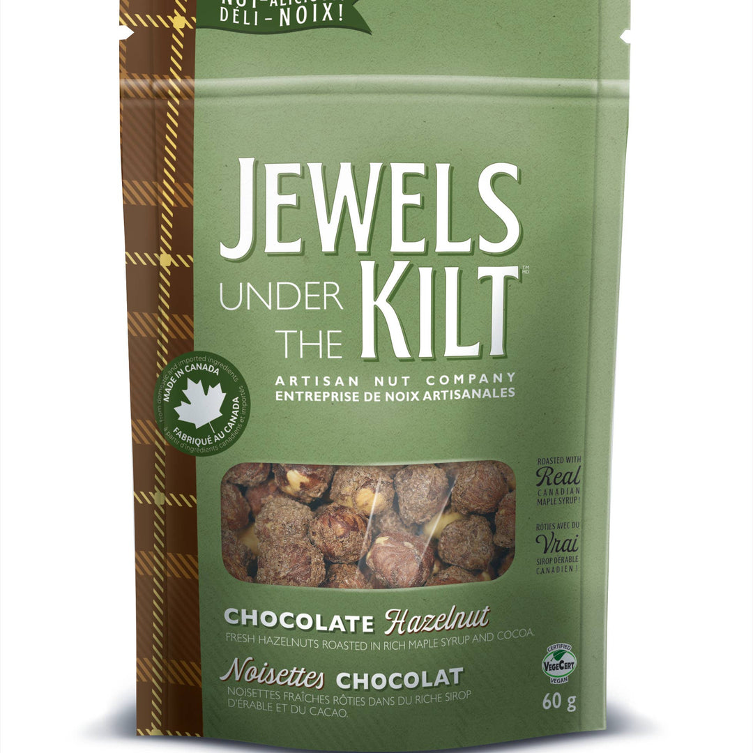 A stand-up pouch of Jewels Under the Kilt Chocolate Hazelnut nuts on a plain white background. The packaging is primarily sage green with a brown plaid pattern on the left side and a clear window showing the nuts inside.