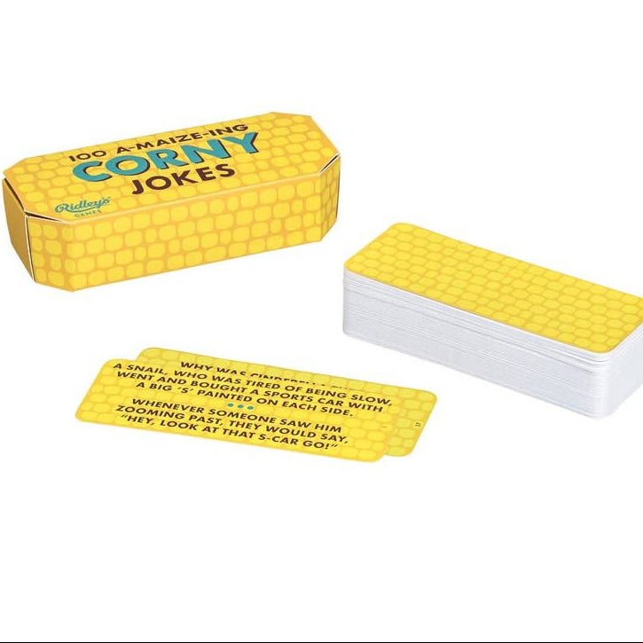 Yellow box of corny jokes with a stack of cards on a white background