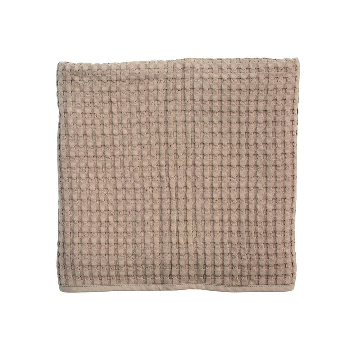 Textured beige square towel on a white background
