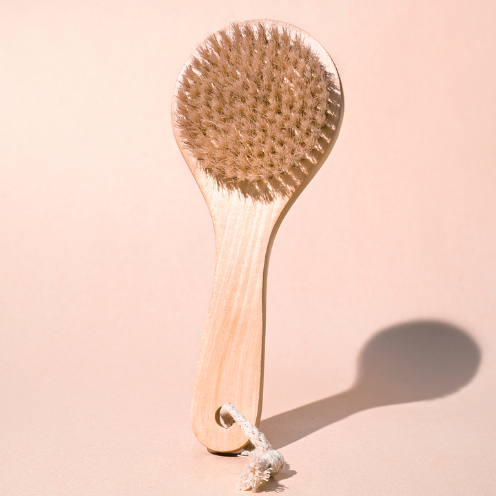 Wooden brush with bristles on a beige background