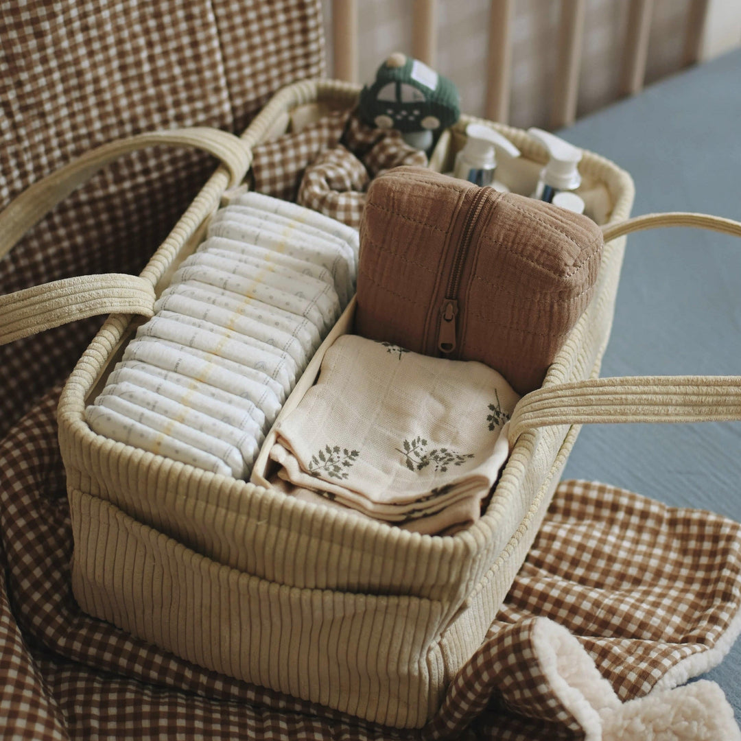 Basket with baby items on a checkered blanket