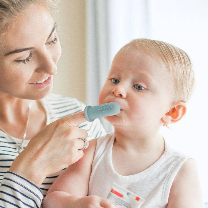 Woman holding a child with a blue device on a white background