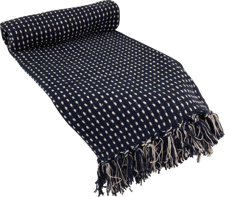 A navy blue and cream checkered woven throw blanket with fringed edges, shown partially rolled on a white background.