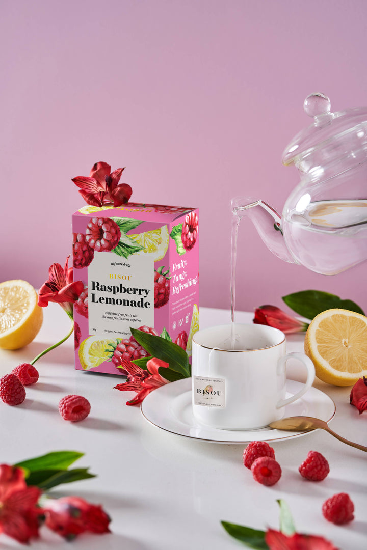 Organic raspberry lemonade herbal tea blend sachets by Bisou Tea, featuring vibrant tea sachets with fresh fruit and herb ingredients.