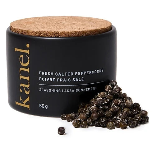 A black cylindrical jar of Kanel fresh salted peppercorns with a cork lid, shown with a small pile of dark peppercorns in front on a white background.