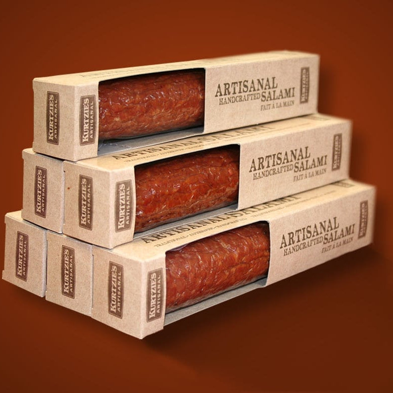 Stack of Kuhns Artisanal Handcrafted Salami boxes on a brown background