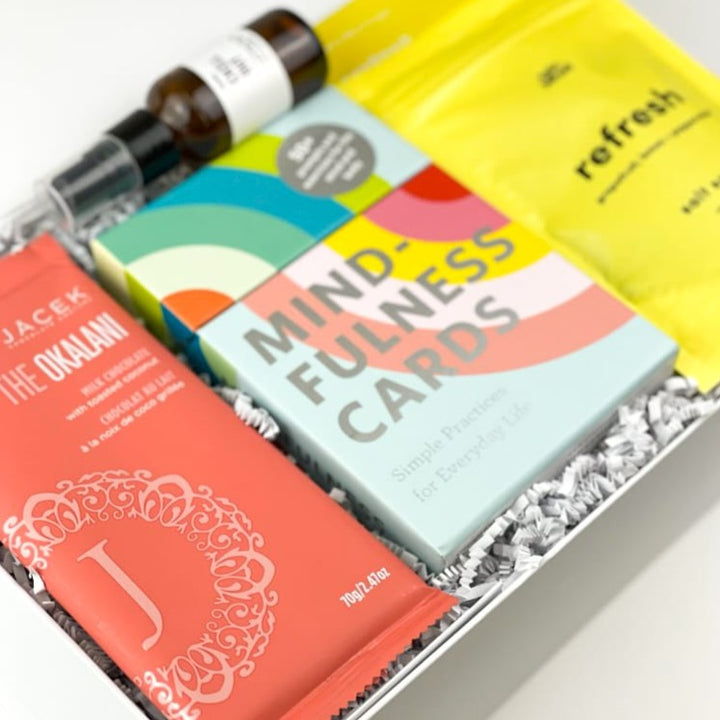 Send them the gift of mental and physical wellness with our luxury Mindful Moment Gift Box! They will love these top-quality relaxation items, along with some delicious JACEK chocolate.  GIFT CONTENTS:  Okalani JACEK Chocolate Bar - Milk Chocolate Coconut Chill Out Essential Oil Spray Mindfulness Cards Epic Blend Refresh Salt Soak Patchology Just Let It Glow Sheet Face Mask