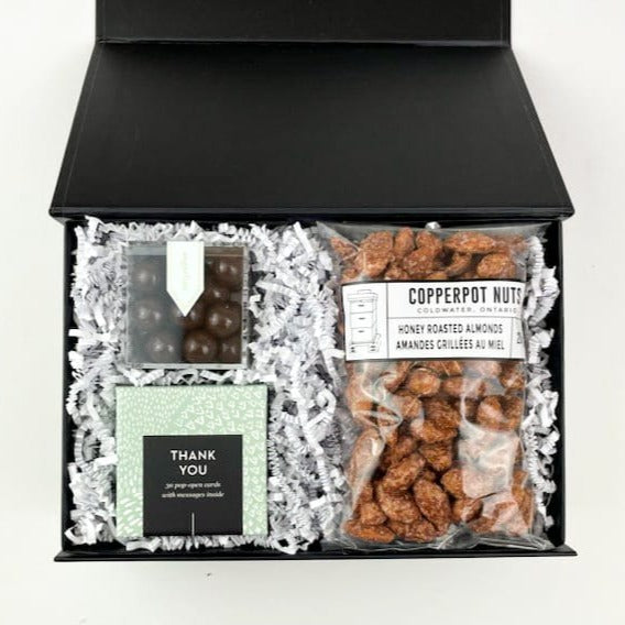 Our Thank You Gift Box is the perfect way to express your gratitude! They will love the thoughtful message cards and indulgent treats.  GIFT CONTENTS:  Thank You Thoughtful Cards - Enjoy 30 Pop Open Cards with an inspirational thank you message. Sugarfina Dark Chocolate Sea Salt Carmels Copperpot Honey Roasted Almonds
