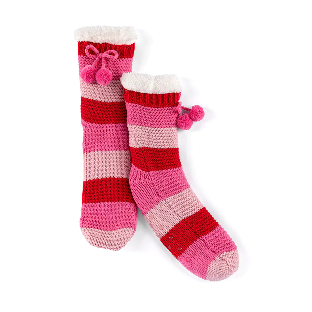 Fuzzy comfort meets polished style in Shiraleah’s Norris Slipper Socks. These socks feature a knitted texture, with a sherpa lining, a tie with pom pom detailing and have a unique feminine flair with its fun stripe print. These socks have a rubber grip bottom and are packaged with a belly band making them the perfect gift option.