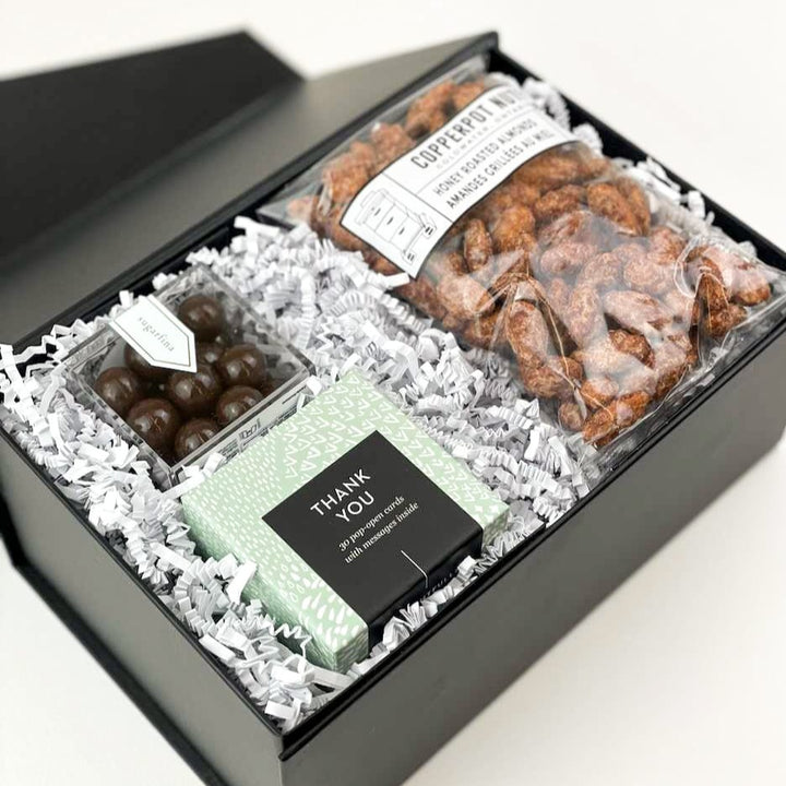Our Thank You Gift Box is the perfect way to express your gratitude! They will love the thoughtful message cards and indulgent treats.  GIFT CONTENTS:  Thank You Thoughtful Cards - Enjoy 30 Pop Open Cards with an inspirational thank you message. Sugarfina Dark Chocolate Sea Salt Carmels Copperpot Honey Roasted Almonds