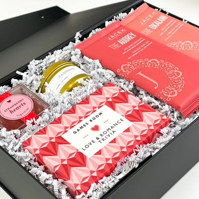 The perfect Valentine's Day gift box for someone you love!  GIFT CONTENTS:  Love & Romance Trivia The Audrey JACEK Chocolate Bar - Dark Chocolate with Cherries & Pistachios Okalani JACEK Chocolate Bar - Milk Chocolate Coconut Cashmere 4oz Gold Tinned Candle Sugarfina Strawberry Hearts