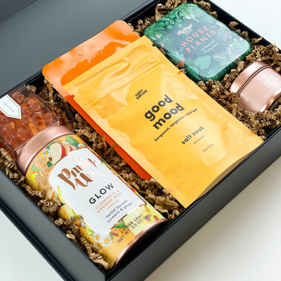 It's time to relax! This luxurious gift box is packed full of a variety of self-care items. Enjoy quality relaxation gifts including skincare, tea, playing cards, and more.  GIFT CONTENTS:  Sugarfina Rosé All Day Bears Pink Up Glow Tea - Herbal Tea with Ginger & Turmeric Epic Blend Good Mood Salt Soak - Bergamot, Tangerine, and Mint Leaf Ridley's Games House Plants Playing Cards Vanilla & Ginger Rose Gold Tinned Candle Vitamin C Face Mask