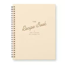A beige recipe book with a French vanilla cover and the title 'The Recipe Book' printed on it.